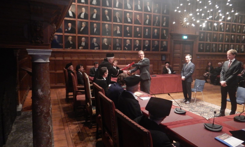 Dr. Jan van Lopik receives his doctorate diploma from his promotor at Utrecht University, Professor Ruud Schotting