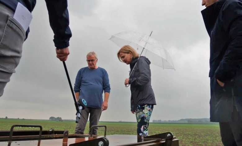 Op gepaste afstand van 1,5 meter wegens coronamaatregelen krijgt minister Van Nieuwenhuizen te midden van de wortelen toelichting over peilgestuurde drainage en ondergrondse waterberging (links: Alex van Hootegem van Meulwaeter, rechts: Teun van Dooren van KWR).